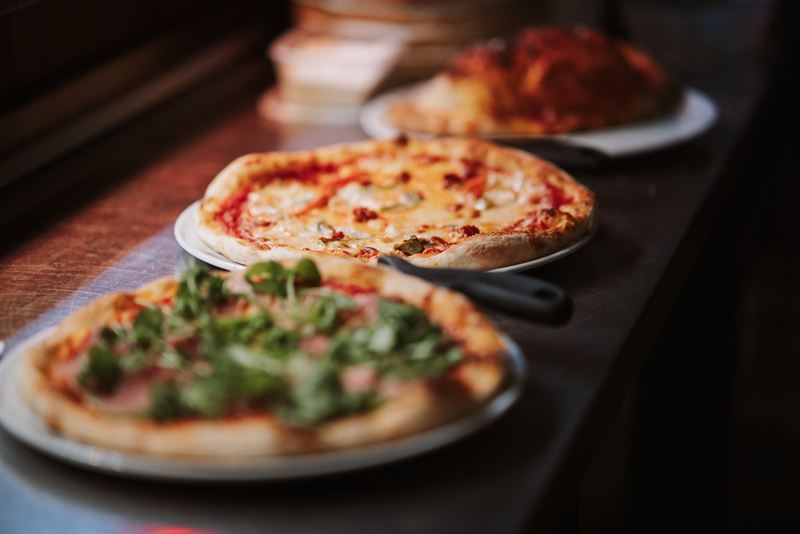 Three stone-baked pizzas lined up on the pass at Nucci